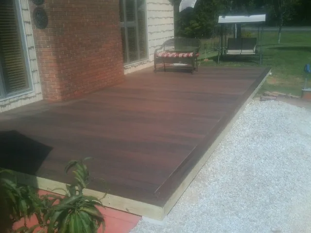 Freshly stained wood deck built against a brick home in Petersburg